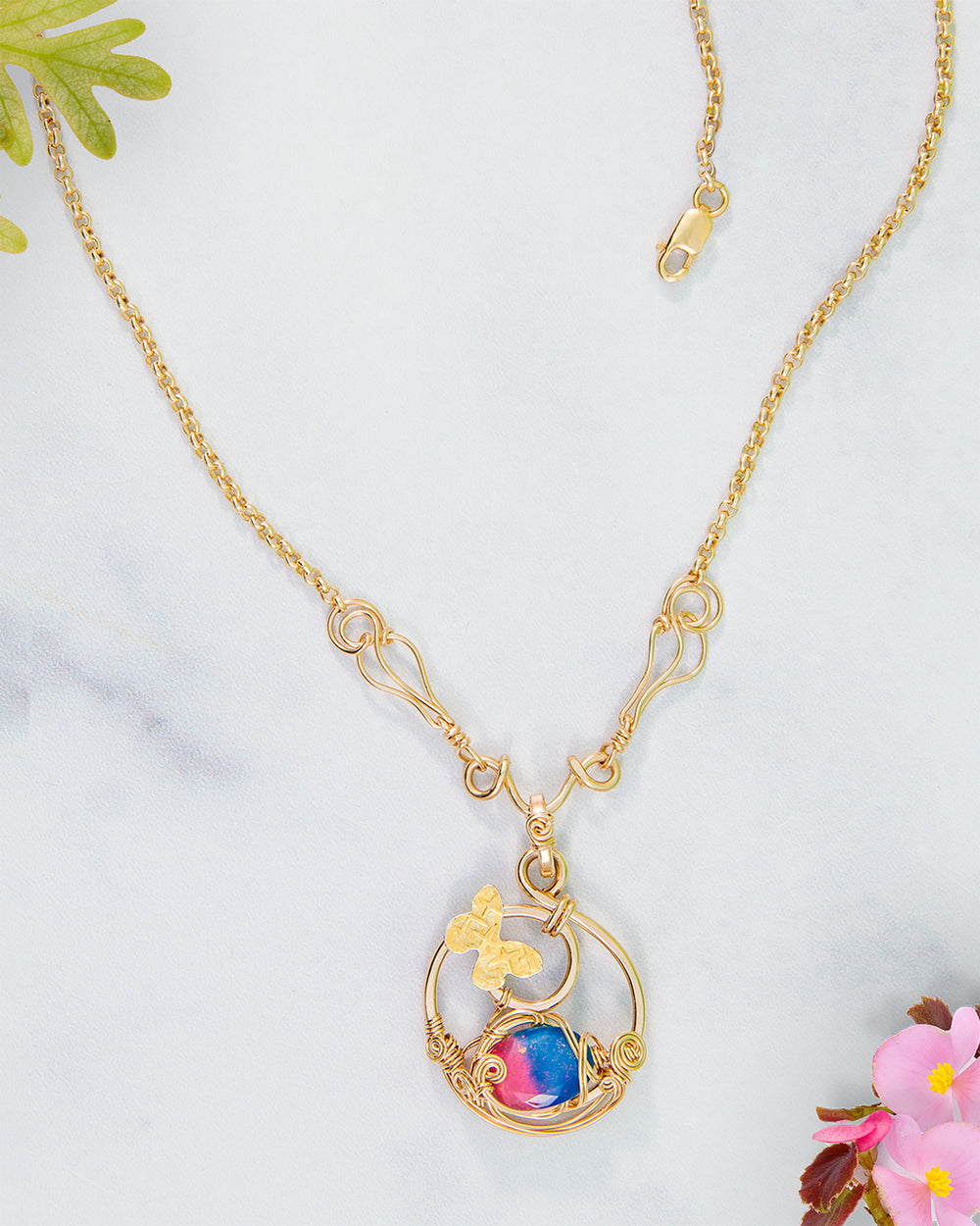 Gold necklace with a colorful  butterfly pendant on a light background